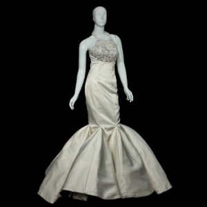 Bride wearing The Bellflower lilac tulle wedding dress, featuring a V-neckline and floral appliqué bodice in a sunlit garden setting.