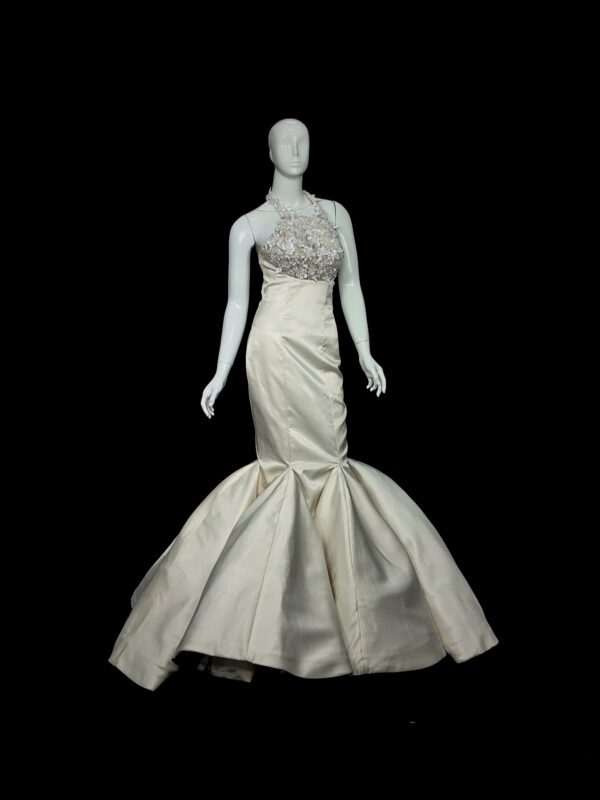 Bride wearing The Bellflower lilac tulle wedding dress, featuring a V-neckline and floral appliqué bodice in a sunlit garden setting.