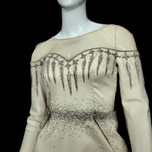 Close-up of the Sovanara Princess wedding dress, highlighting the intricate lacework, beaded floral appliqués, and off-shoulder neckline.